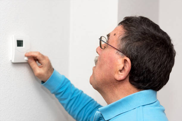 istock Man adjusting thermostat at home, focus on face. Celsius temperature scale. 1064704070