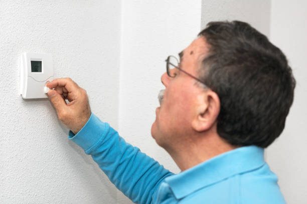 istock Man adjusting thermostat at home, focus on thermostat. Celsius temperature scale. 1064704678