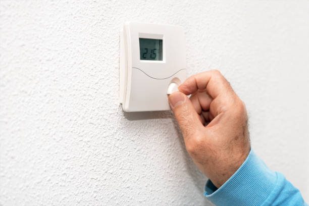 istock Man hand adjusting thermostat at home. Celsius temperature scale. 1064705226