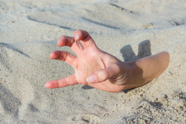 istock Hand closeup. Hands buried in sand on a beach. 1064709162