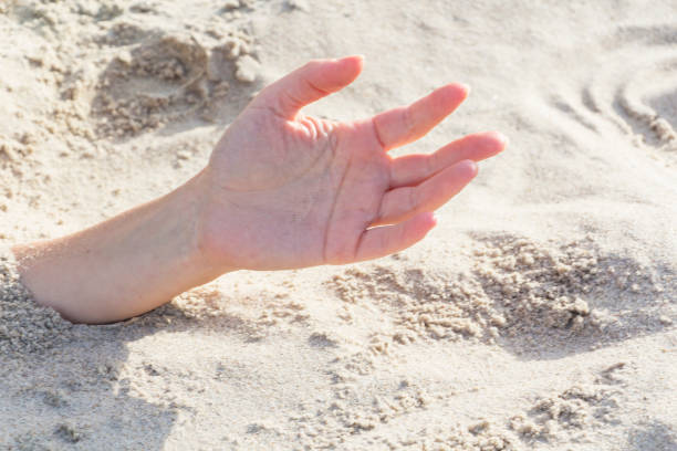 istock Hand closeup. Hands buried in sand on a beach. 1064709226