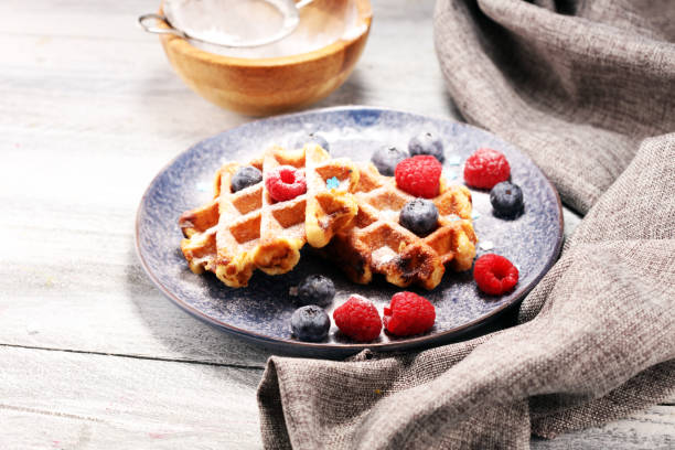 istock waffles with fresh blueberries, sugar and raspberries. 1064710426