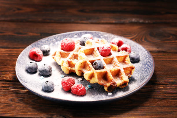 istock waffles with fresh blueberries, sugar and raspberries. 1064713240
