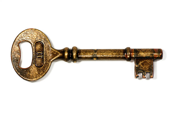 old golden key Macro view of an old golden key with the number 11 isolated on a white background. antique key stock pictures, royalty-free photos & images