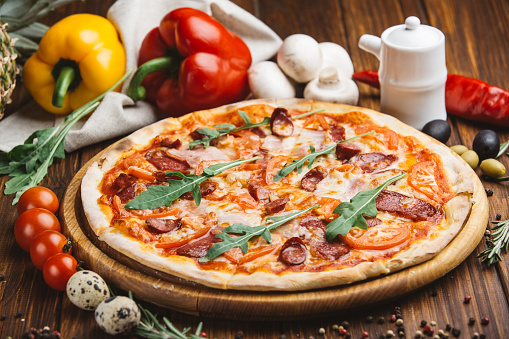 Pizza with meat and cheese on a vegetable background