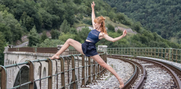 istock Young dancing modern and ballet on bridge on a train rail 1064718904