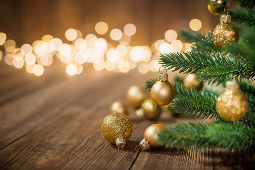 Christmas Tree decorated with christmas balls on rustic wood and sparkles / defocused lights on the backgorund. Copy space for creative use.