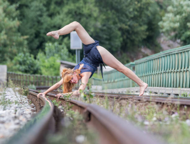 istock Young dancing modern and ballet on bridge on a train rail 1064720894
