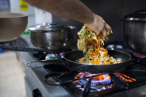istock chef is cooking vegatabels with saute pan 1064723614