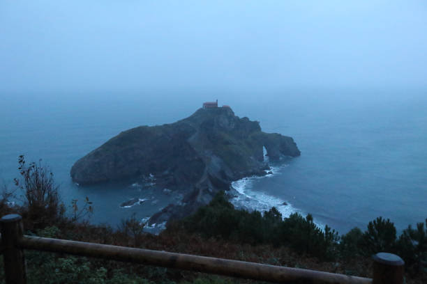 ガルテルガトシェ膵島とバスクの国, スペイン、荒れた海での霧の冬夜の間に岩 - mist rock winter autumn ストックフォトと画像