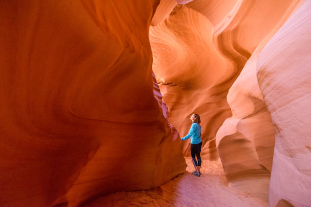 mujer joven en antelope canyon en arizona. turismo en antelope canyon. concepto de aventura y senderismo. - cave canyon rock eroded fotografías e imágenes de stock