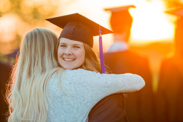 istock Two women hug at a graduation ceremony 1064732600