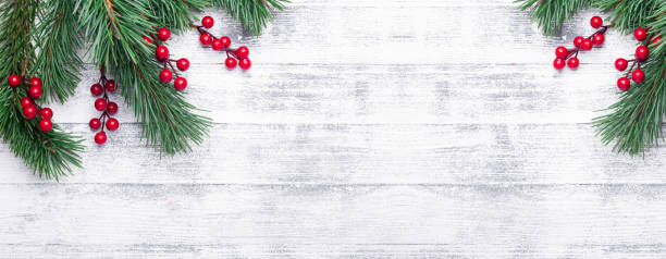 istock Christmas background with tree branches and holly berries. White wooden table 1064736362