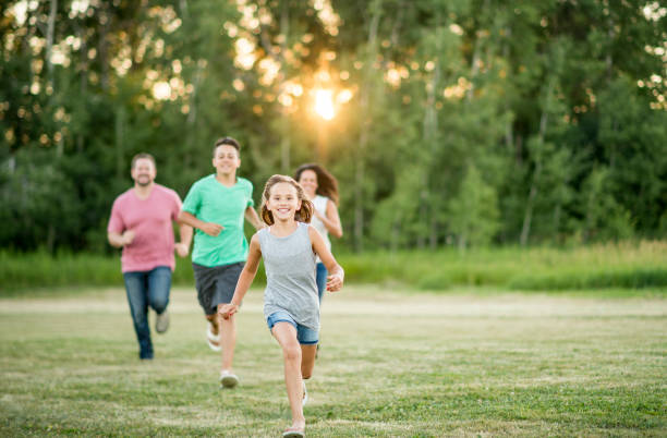 istock Family running through a grassy field on a sunny day 1064736378