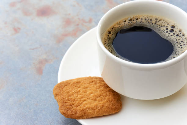 istock Cup filled with black coffee on saucer and biscuit 1064737566