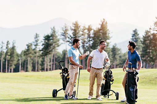 Multi-ethnic group of young men walking on a golf course