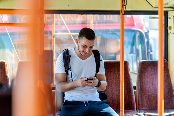 istock Young Man in the Bus with Smart Phone 1064740086