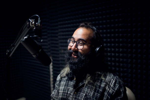 istock Young male dj works in modern broadcasting studio 1064742848