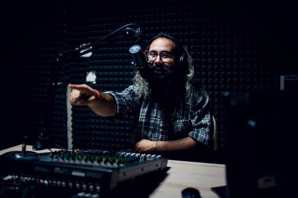 istock Young male dj works in modern broadcasting studio 1064742922