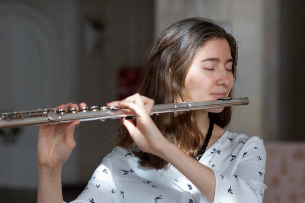 istock A beautiful woman posing while playing on a flute 1064743974