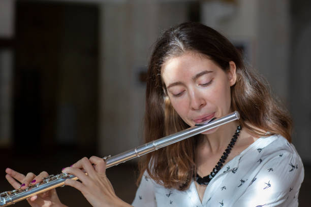 istock A beautiful woman posing while playing on a flute 1064745626