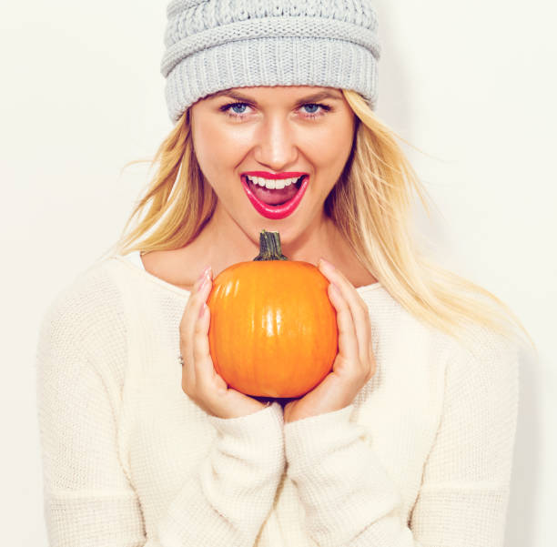 istock Young woman holding pumpkins 1064746194