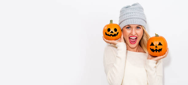 istock Young woman holding pumpkins 1064746286
