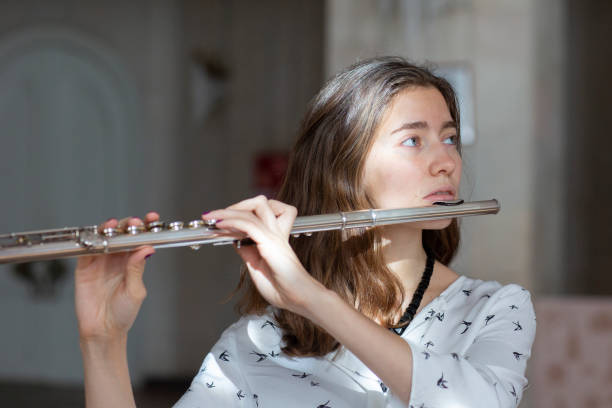 istock A beautiful woman posing while playing on a flute 1064746324