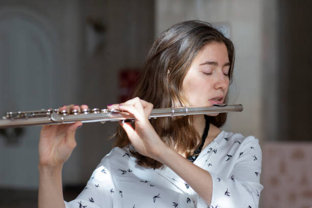 istock A beautiful woman posing while playing on a flute 1064746482