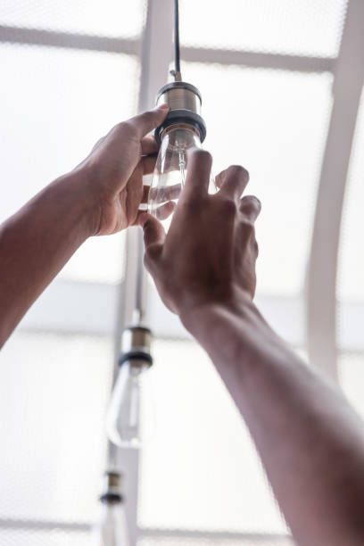 istock Low angle view of unrecognizable black man changing a lightbulb 1064751098