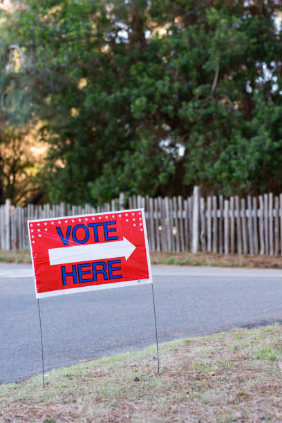 istock Voting Polling Place sign in front road and gate 1064760414