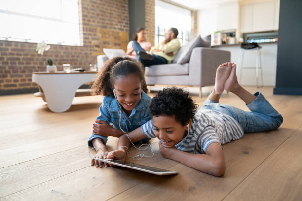 istock Happy children at home watching videos on a tablet computer 1064761878