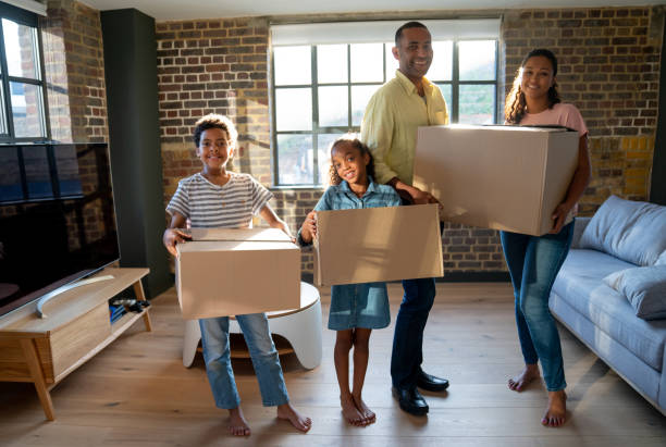 istock Happy family moving house and packing in boxes 1064763354