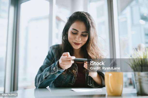 Beautiful Young Woman Depositing Check With Smartphone Stock Photo - Download Image Now