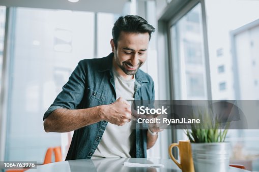 istock Adult Man Depositing Check With Smartphone 1064763976