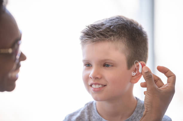istock Doctor helps young boy with hearing aid 1064763988