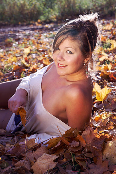 The sexual girl lies on autumn leaves stock photo