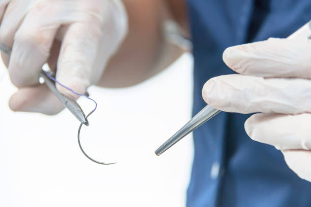 istock Doctor holding surgical forceps suture needle, suturing material 1064774860