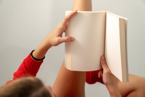 istock woman in red is reading book while lying down mock-up template 1064786120