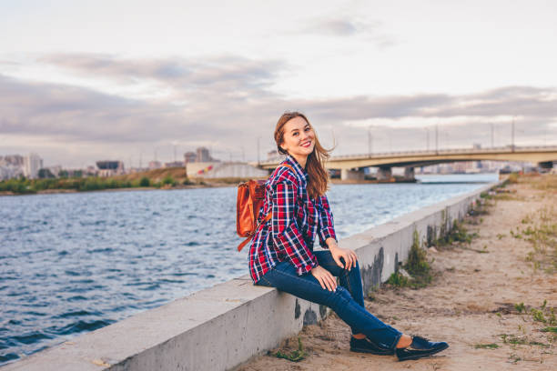 istock Smiling woman sitting on the riverbank 1064788496
