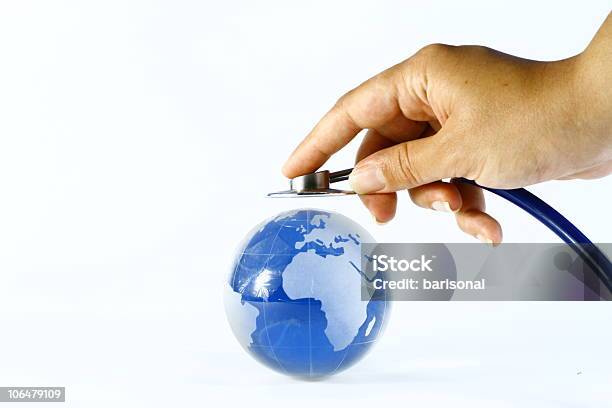 Hand Holds Stethoscope Up To World Globe Global Healthcare Stock Photo - Download Image Now