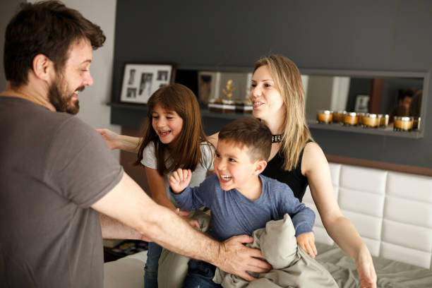 istock Parents playing with son and daughter on bed 1064799570