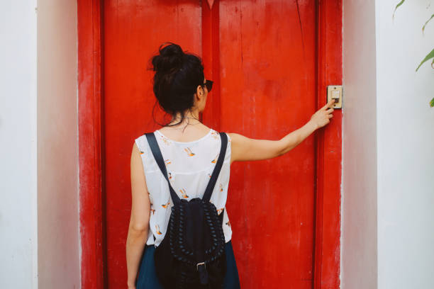 Ringing the door bell Young woman visiting her friend in Bangkok, Thailand, ringing the doorbell. doorbell photos stock pictures, royalty-free photos & images