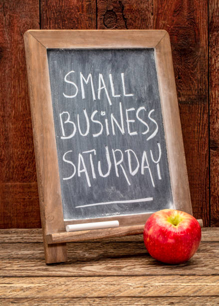 Small Business Saturday blackboard sign Small Business Saturday sign - white chalk handwriting on a blackboard agains rustic barn wood - holiday shopping concept small business saturday stock pictures, royalty-free photos & images
