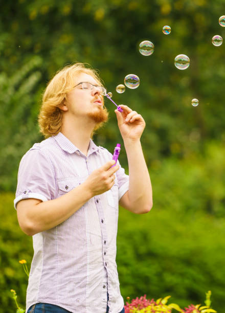 istock Man blowing soap bubbles outdoor 1064810308