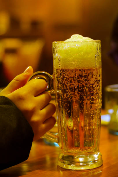 istock beer glass in hand 1064816202
