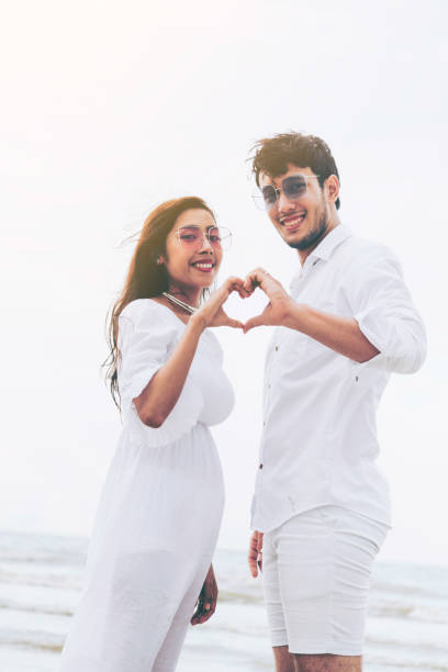istock Young couple shows heart shape hand gesture. 1064837056