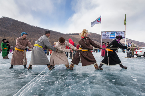 Hatgal, Mongolia, 4th March 2018: mongolian people dressed in traditional clothing on a frozen lake Khuvsgul competing in tug-of-war