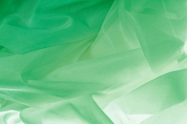 istock Texture, background, pattern. The texture of the silk fabric is green. Silk fabric is transparent. Fabric or liquid wave illustration of wavy creases of silk satin texture or velvet material 1064841162