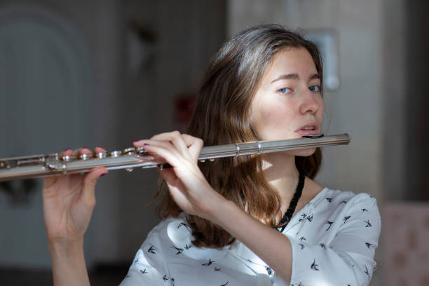 istock A beautiful woman posing while playing on a flute 1064841184